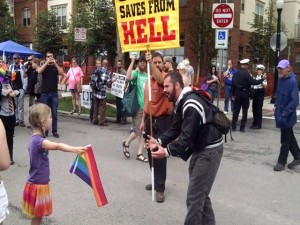Una niña se enfrenta a un fanático religioso portando la bandera multicolor a favor de la igualdad de derechos
