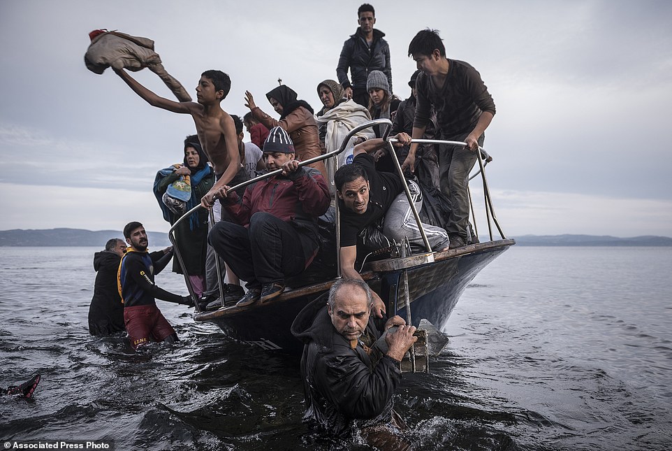 In this image released by World Press Photo titled "Reporting Europe's Refugee Crisis" by photographer Sergey Ponomarev for The New York Times which won the first prize in the General News Stories category shows refugees arriving by boat near the village of Skala on Lesbos, Greece, 16 November 2015. (Sergey Ponomarev for The New York Times, World Press Photo via AP)