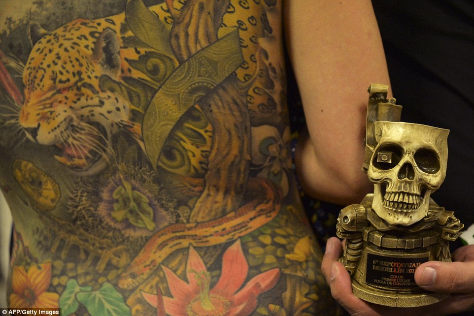 29D27E3100000578-3133591-Victorious_A_tattoo_artist_shows_off_his_trophy_with_his_winning-a-6_1434918853390