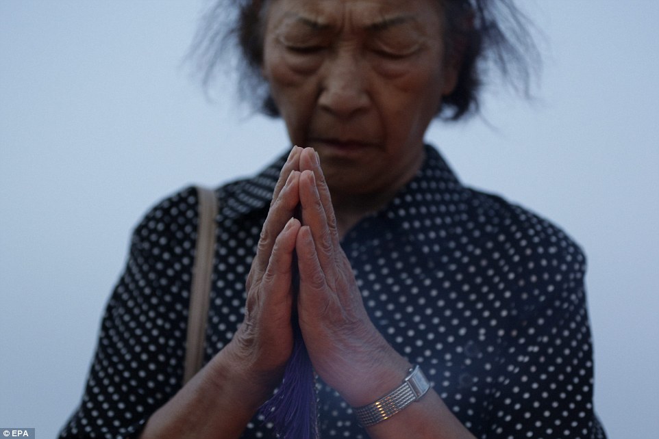 2B23695000000578-3186815-A_woman_is_seen_deep_in_prayer_at_Hiroshima_s_Peace_Memorial_Par-a-91_1438857513515