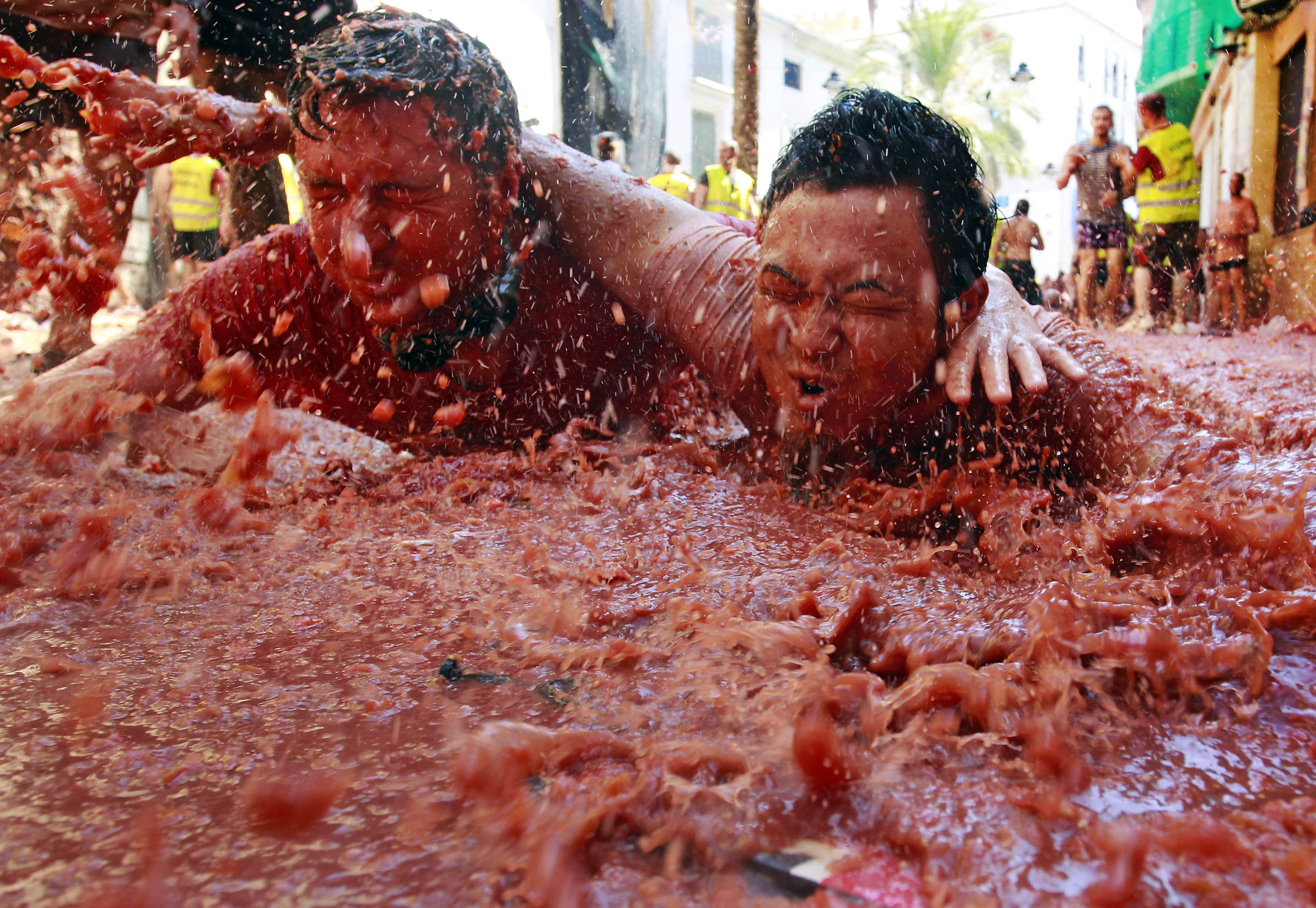 Revelers play in tomato pulp during the annual "tomatina" tomato fight fiesta in the village of Bunol, near Valencia, Spain, Wednesday, Aug. 29, 2012.