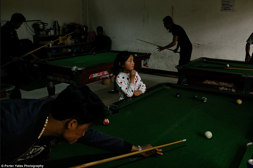 2D04B91000000578-3257757-A_young_girl_watches_men_play_pool_inside_a_billiards_hall_in_Ga-a-96_1443800113810