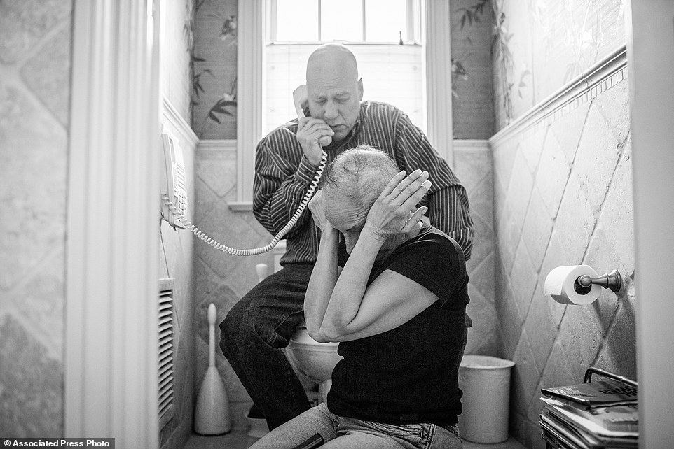 In this image released by World Press Photo titled "A Life in Death" by photographer Nacy Borowick which won second prize Long Term Projects shows Howie and Laurel Borowick sitting next to the bathroom telephone as they receive the most recent news from their oncologist. New York, US, March 8, 2013. A daughter photographs her own parents who were in parallel treatment for stage-four cancer, side by side. The project looks at love, life, and living, in the face of death. It honors their memory by focusing on their strength and love, both individually and together, and shares the story of their final chapters, within a year of each other. (Nancy Borowick, World Press Photo via AP)
