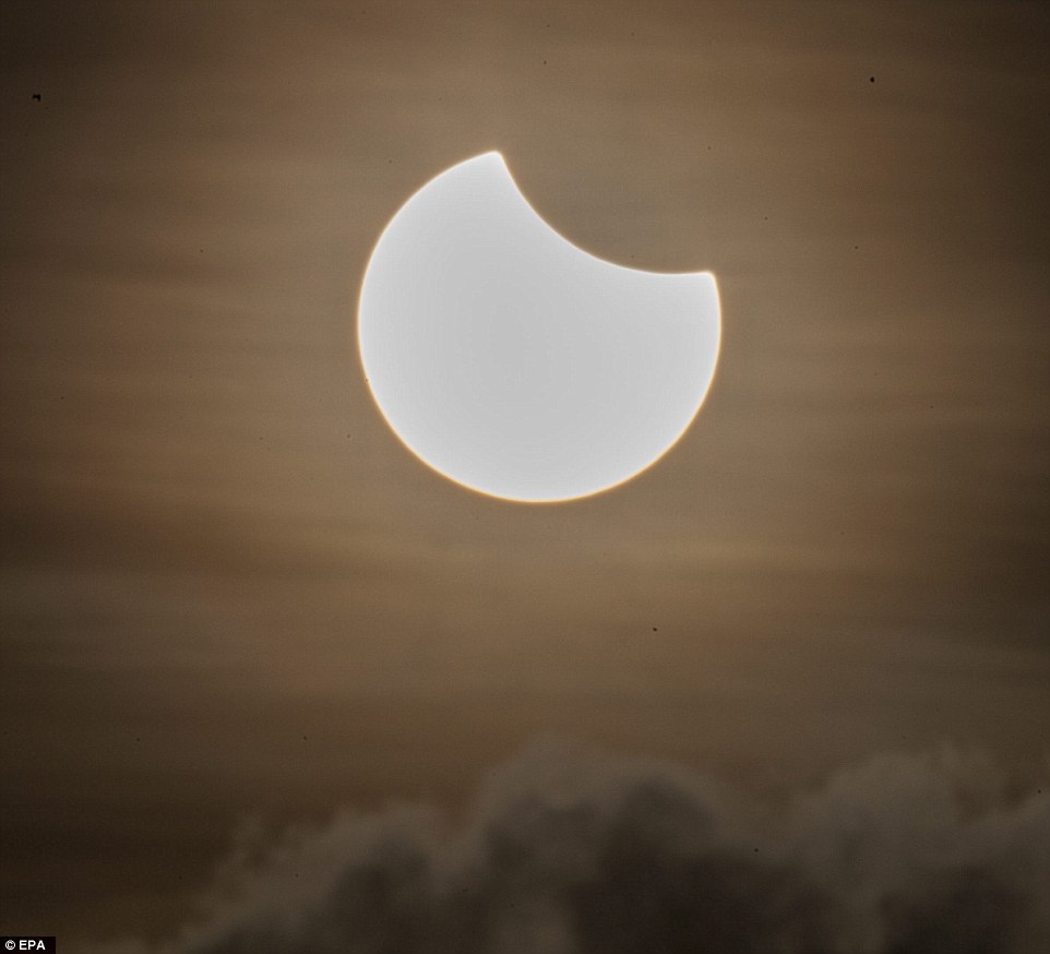 3203573700000578-3482995-A_partial_solar_eclipse_is_pictured_above_a_cloud_formation_at_d-a-1_1457509410387